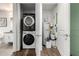 Efficient laundry area with stacked washer/dryer and a water heater, neatly organized with cleaning supplies at 3131 N Central Ave # 6010, Phoenix, AZ 85012