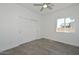 Bright bedroom features a ceiling fan, closet with sliding doors, and a window overlooking the yard at 32017 N Redding St, Wittmann, AZ 85361