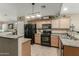 Functional kitchen featuring a breakfast bar, black appliances, light wood cabinetry, and tile flooring at 3313 W Five Mile Peak Dr, San Tan Valley, AZ 85144