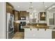 Bright kitchen features granite counters, stainless appliances, wood look tile flooring, and modern pendant lights at 3330 E Carla Vista Dr, Gilbert, AZ 85295