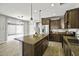 Charming kitchen features granite counters, an island, stainless steel appliances, and wood look tile flooring at 3330 E Carla Vista Dr, Gilbert, AZ 85295