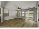 Spacious living room with neutral paint, wood look tile, and a sliding glass door to the backyard at 3330 E Carla Vista Dr, Gilbert, AZ 85295