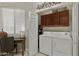 Convenient laundry room with washer, dryer, storage cabinets, and window for natural light at 3330 S Gilbert Rd # 2021, Chandler, AZ 85286