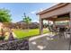 Beautiful backyard with synthetic grass, outdoor dining area and landscaping, perfect for relaxation at 4089 E Peach Tree Dr, Chandler, AZ 85249