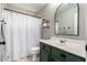 Bathroom features an arched mirror, green cabinets, and decorative shelves at 4109 E Chambers St, Phoenix, AZ 85040