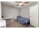 Carpeted bedroom showcases a bed, white desk, and ceiling fan at 4109 E Chambers St, Phoenix, AZ 85040