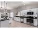 Bright kitchen features white cabinets, stainless steel appliances, black countertops, and tile flooring at 4109 E Chambers St, Phoenix, AZ 85040