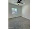 Bright bedroom with a ceiling fan, carpet flooring and a window overlooking the neighborhood at 4116 E Park St, Phoenix, AZ 85042