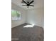 Bedroom featuring a ceiling fan, natural light from the window, and neutral carpet flooring at 4116 E Park St, Phoenix, AZ 85042