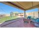 Inviting covered patio with outdoor seating and view of playset and trampoline in grassy backyard at 4138 N 298Th Ln, Buckeye, AZ 85396