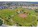Aerial view of community baseball fields and green space surrounded by homes and desert landscape at 4138 N 298Th Ln, Buckeye, AZ 85396