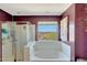 An elegant bathroom featuring a soaking tub with desert views and a separate glass enclosed shower at 4138 N 298Th Ln, Buckeye, AZ 85396