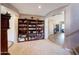 Inviting entryway with tiled floors, a large wooden bookshelf, and arched doorways at 4138 N 298Th Ln, Buckeye, AZ 85396