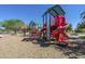 Vibrant community playground featuring multiple slides, climbing structures, and shaded areas for enjoyment at 4138 N 298Th Ln, Buckeye, AZ 85396