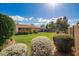 A well-maintained backyard showcasing a large lawn, lush foliage, and sunny skies at 4232 W Purdue Ave, Phoenix, AZ 85051