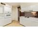 Clean kitchen features white appliances and white cabinets at 4232 W Purdue Ave, Phoenix, AZ 85051