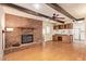 Open-concept living area with hardwood floors, a brick fireplace, and a view into the kitchen at 4232 W Purdue Ave, Phoenix, AZ 85051