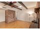 A spacious living area with hardwood floors, exposed beam ceiling, brick accent wall, and open floorplan at 4232 W Purdue Ave, Phoenix, AZ 85051