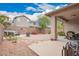 Spacious backyard featuring rock landscaping, a fire pit, seating, and a covered patio with a grill at 43828 W Roth Rd, Maricopa, AZ 85138
