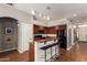 Open kitchen features bar seating, track lighting, ample cabinet space, and modern appliances at 43828 W Roth Rd, Maricopa, AZ 85138