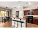 Spacious kitchen with bar seating, updated black appliances, and seamless transition to dining area at 43828 W Roth Rd, Maricopa, AZ 85138