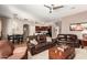 Comfortable living room with plush leather sofas, ceiling fan, and open access to dining and kitchen at 43828 W Roth Rd, Maricopa, AZ 85138