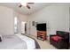 Comfortable bedroom area with a TV set on a wooden cabinet and a sitting chair at 43828 W Roth Rd, Maricopa, AZ 85138