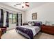 Serene main bedroom featuring a large window, soft carpet, and a decorative ceiling fan at 43828 W Roth Rd, Maricopa, AZ 85138