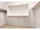 Bright empty walk-in closet with carpet flooring and wooden racks for storage at 43828 W Roth Rd, Maricopa, AZ 85138