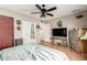 Spacious bedroom with hardwood floors, closet, ceiling fan, and a television at 4402 N 79Th Dr, Phoenix, AZ 85033