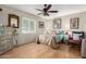Comfortable bedroom featuring hardwood floors, a ceiling fan, and a window with shutter-style blinds at 4402 N 79Th Dr, Phoenix, AZ 85033