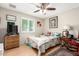 Cozy bedroom with a ceiling fan, hardwood floors, and a window with shutter-style blinds at 4402 N 79Th Dr, Phoenix, AZ 85033