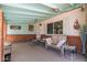 Relaxing covered patio features neutral toned outdoor seating, brick accents, and ceiling fan at 4402 N 79Th Dr, Phoenix, AZ 85033