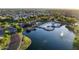 Aerial view showcases the community's serene lake, clubhouse, and swimming pool surrounded by lush landscaping at 44355 W Oster Dr, Maricopa, AZ 85138