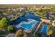 Aerial view showcases the community's serene lake, swimming pool, and lush landscaping for relaxation and recreation at 44355 W Oster Dr, Maricopa, AZ 85138