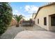 This backyard features gravel landscaping, a block wall, a palm tree and a trampoline at 44355 W Oster Dr, Maricopa, AZ 85138