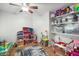 Spacious bedroom features ceiling fan, tile flooring, and built-in shelving for easy organization at 44355 W Oster Dr, Maricopa, AZ 85138