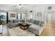Beautiful living room with a large sectional sofa, bright tile flooring, and modern decor at 44355 W Oster Dr, Maricopa, AZ 85138