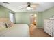 Comfortable main bedroom with ceiling fan, carpet, and access to en-suite bathroom at 44355 W Oster Dr, Maricopa, AZ 85138