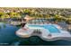 Aerial view of the pool and lake with resort-style amenities and mature landscaping at this beautiful community at 44355 W Oster Dr, Maricopa, AZ 85138