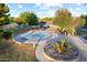 Aerial view of a grassy recreation area with benches, mature trees and seating near the community lake at 44355 W Oster Dr, Maricopa, AZ 85138