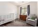 Cozy Bedroom with a crib, dresser, and comfortable chair for a relaxing space at 4495 E Woodside Way, Gilbert, AZ 85297