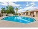 A well-maintained community pool and spa area with lounge chairs, surrounded by lush landscaping at 520 N Stapley Dr # 181, Mesa, AZ 85203