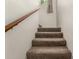 Carpeted stairs with a wooden handrail lead to the upper level at 520 N Stapley Dr # 181, Mesa, AZ 85203