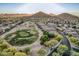 Stunning aerial view of a desert community with a golf course and mountain backdrop at 582 W Stirrup Ln, San Tan Valley, AZ 85143