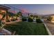 Spacious backyard featuring lush green lawn, desert landscaping, and mature plantings offering a private and serene retreat at 582 W Stirrup Ln, San Tan Valley, AZ 85143