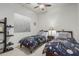 A shared bedroom featuring two twin beds, a ceiling fan, and a dark bookcase at 582 W Stirrup Ln, San Tan Valley, AZ 85143