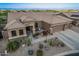 Exterior view of home showcasing desert landscaping, a three-car garage, and a quaint front porch at 582 W Stirrup Ln, San Tan Valley, AZ 85143