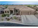 Exterior view of home featuring desert landscaping, a three-car garage, and a charming front porch at 582 W Stirrup Ln, San Tan Valley, AZ 85143