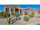 Well-manicured desert landscape featuring mature cacti, blooming flowers and decorative rock surrounding a contemporary stucco home exterior at 582 W Stirrup Ln, San Tan Valley, AZ 85143